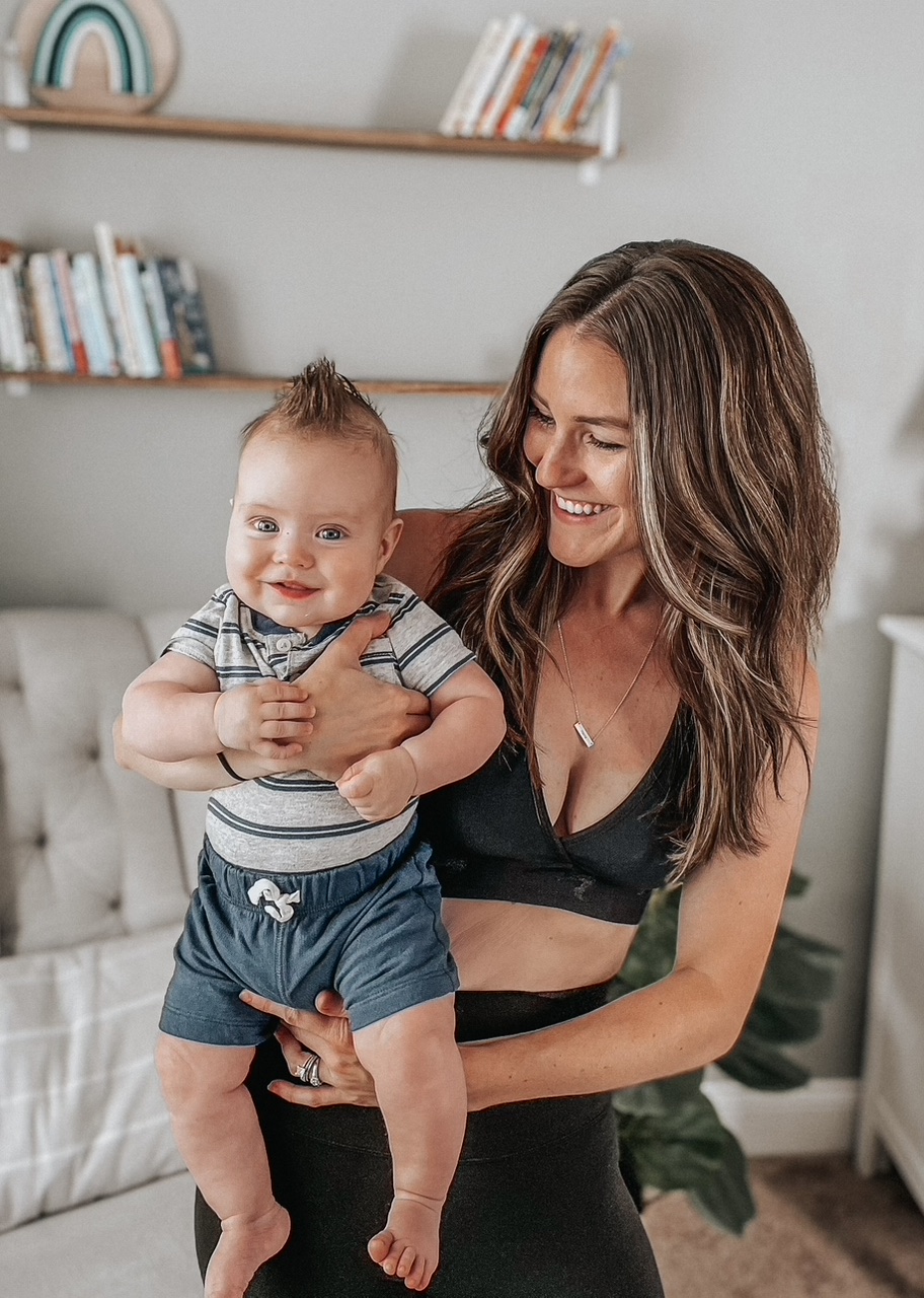 Gen Z parent cradling her happy infant—an authentic image of modern motherhood for brands targeting Gen Z moms.