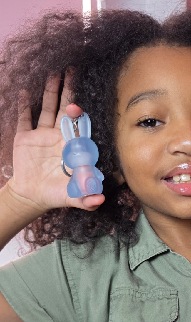 Gen Alpha young girl holding a lipgloss that her Millenial parent bought her.
